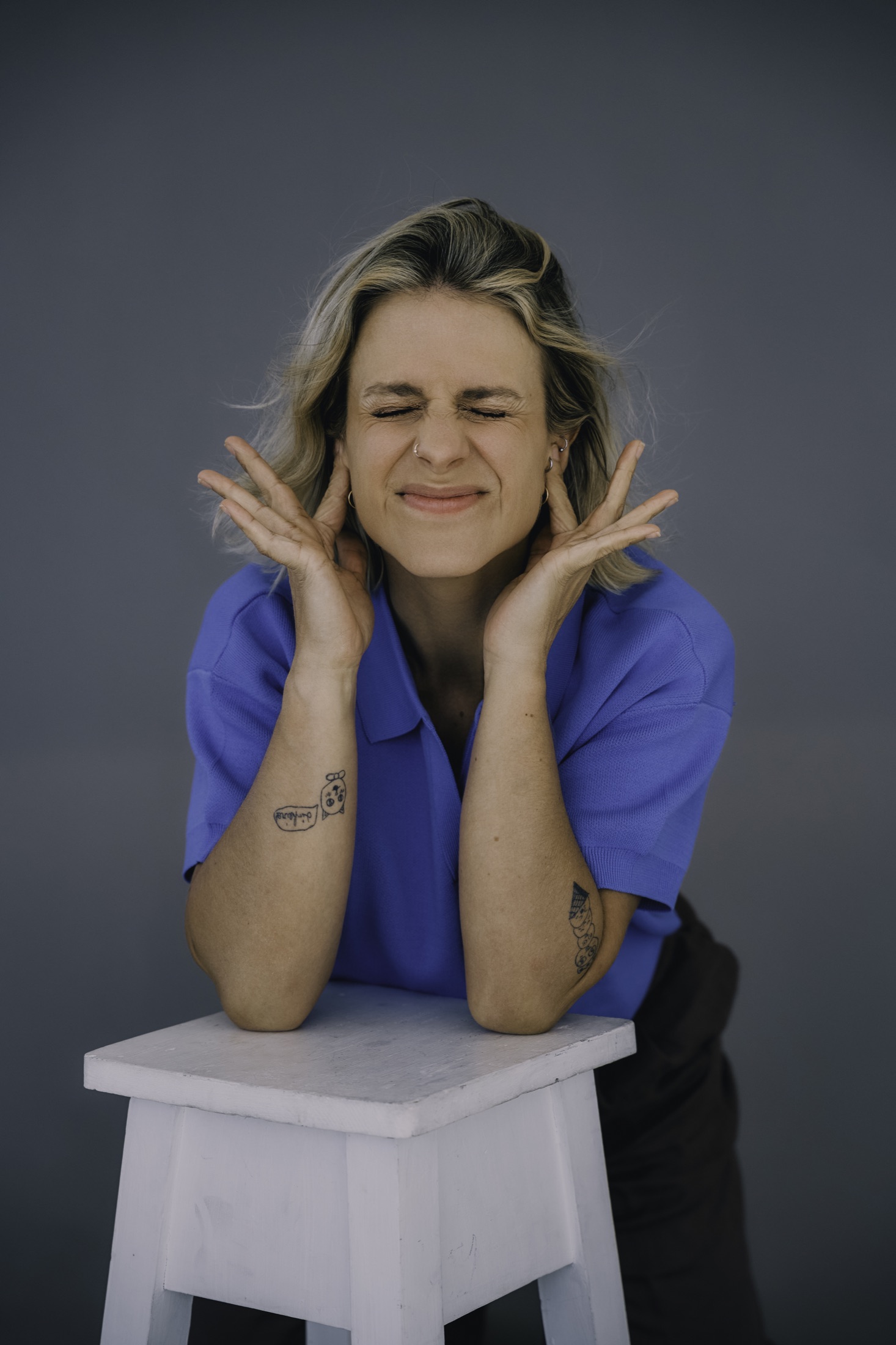 Joana Gama com um polo azul e as mãos junto ao rosto