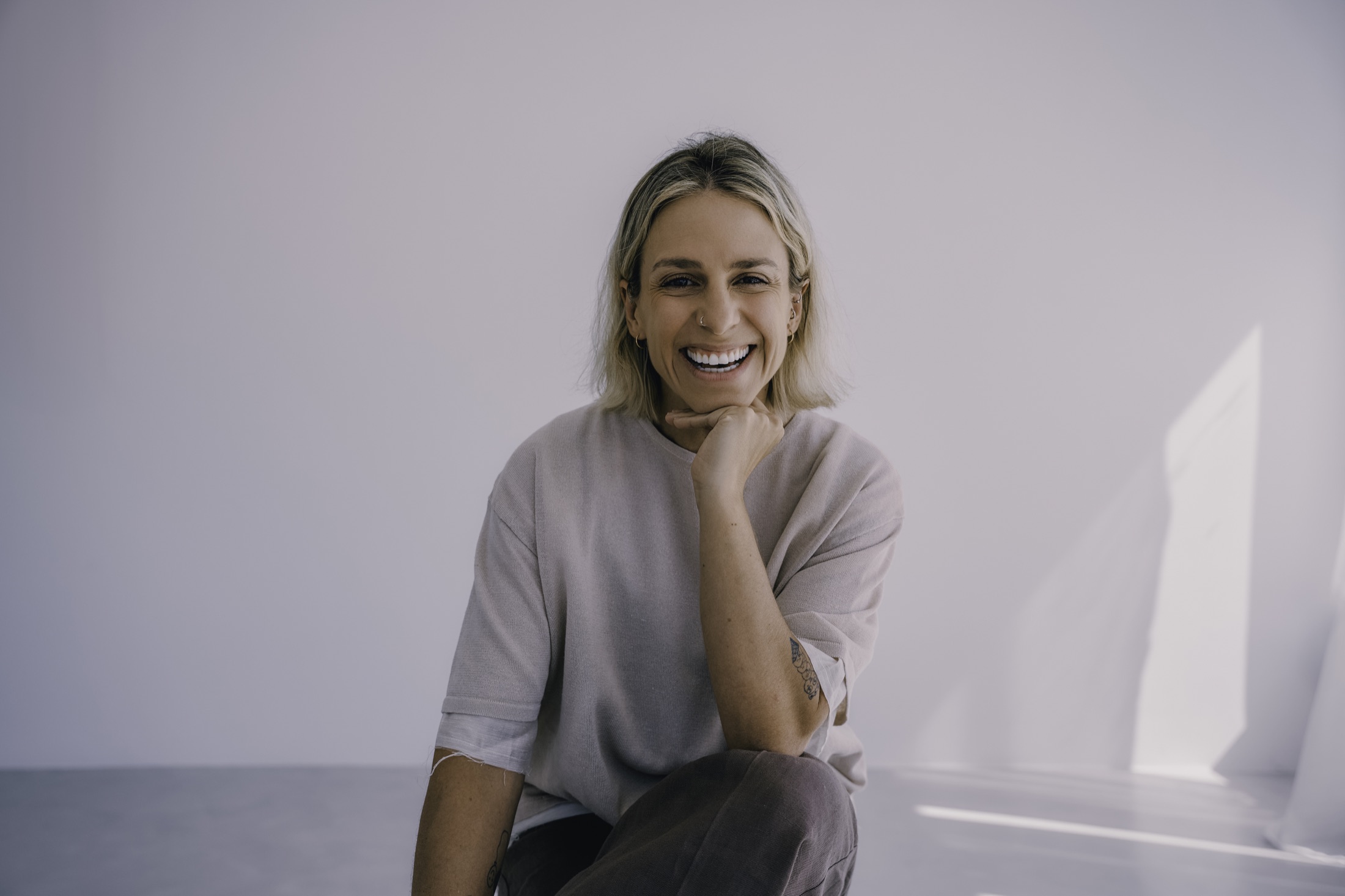 Joana Gama sentada e a sorrir num estúdio luminoso